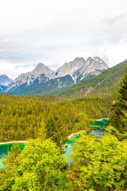 Almanya 'nın en büyük dağının panoramik manzarası Zugspitze alp manzarası turkuvaz rengi Blindsee gölü orman tepeleri ve Alpler' deki dağlar Biberwier Reutte Tyrol Avusturya.