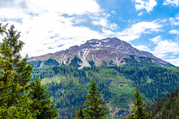 Красивый вид на гору Мариенберг в австрийском Тироле с зелеными лесными скалами и горами в Альпах.