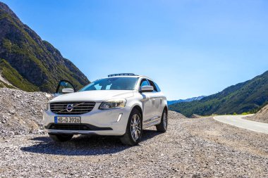 Imst Tyrol Avusturya 31. Mayıs 2025 Dağ ve Alp Dağları 'ndaki beyaz SUV araç kamyonu Alpler Tyrol Avusturya' da kayalık doğa ve mavi gökyüzü ile dağ ve kaya zirveleri.