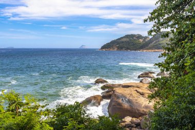 Rio de Janeiro Eyaleti Rio de Janeiro Brezilya 'da, Urca Red Beach Tropikal Cenneti Mavi Turkuaz Su Dalgaları Palmiye Ağaçları Kayalık Tepeler Kayalık Tepeler Sahil Kumu ve Beyaz Sahil Kumu.