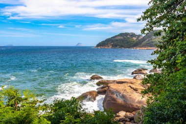 Rio de Janeiro Eyaleti Rio de Janeiro Brezilya 'da, Urca Red Beach Tropikal Cenneti Mavi Turkuaz Su Dalgaları Palmiye Ağaçları Kayalık Tepeler Kayalık Tepeler Sahil Kumu ve Beyaz Sahil Kumu.