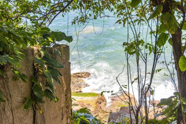 Rio de Janeiro Eyaleti Rio de Janeiro Brezilya 'da, Urca Red Beach Tropikal Cenneti Mavi Turkuaz Su Dalgaları Palmiye Ağaçları Kayalık Tepeler Kayalık Tepeler Sahil Kumu ve Beyaz Sahil Kumu.