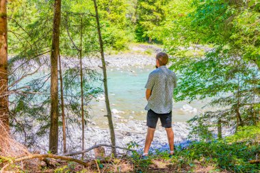 Bir adam Alplerdeki turkuaz bir nehre işiyor ve işiyor. Uçamayan Landeck Tyrol Avusturya.