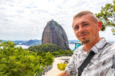 Yakışıklı Gezgin Şeker Somun Dağı Tepesi 'nde poz veriyor Rio de Janeiro Brezilya' nın Urca Köyü 'nde Pao de Acucar Panorama Manzarası.