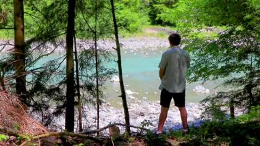 Bir adam Alplerdeki turkuaz bir nehre işiyor ve işiyor. Uçamayan Landeck Tyrol Avusturya.