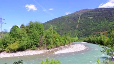 Turkuaz mavi ve yeşil nehir buharı ve taşlı şelale hanı. Çimen ağaçları, doğa ve dağ manzarası Alpler Zams Landeck Tyrol Avusturya 'da..