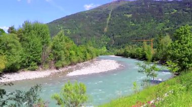 Turkuaz mavi ve yeşil nehir buharı ve taşlı şelale hanı. Çimen ağaçları, doğa ve dağ manzarası Alpler Zams Landeck Tyrol Avusturya 'da..