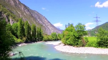 Turkuaz mavi ve yeşil nehir buharı ve taşlı şelale hanı. Çimen ağaçları, doğa ve dağ manzarası Alpler Zams Landeck Tyrol Avusturya 'da..