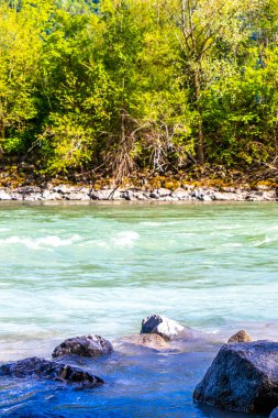 Turkuaz mavi ve yeşil nehir buharı ve taşlı şelale hanı Alpler Zams Landeck Tyrol Avusturya 'daki dağlar arasındaki çimen ağaçları..