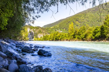 Turkuaz mavi ve yeşil nehir buharı ve taşlı şelale hanı Alpler Zams Landeck Tyrol Avusturya 'daki dağlar arasındaki çimen ağaçları..