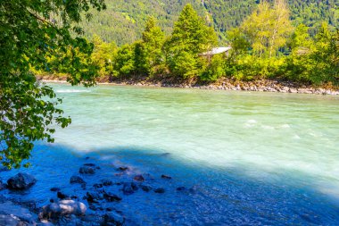 Turkuaz mavi ve yeşil nehir buharı ve taşlı şelale hanı. Çimen ağaçları, doğa ve dağ manzarası Alpler Zams Landeck Tyrol Avusturya 'da..
