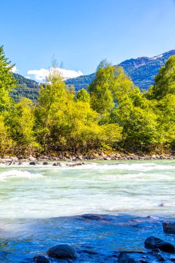 Turkuaz mavi ve yeşil nehir buharı ve taşlı şelale hanı Alpler Zams Landeck Tyrol Avusturya 'daki dağlar arasındaki çimen ağaçları..