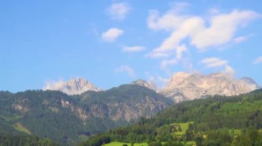 Yeşil tarlalar, orman bulutları, arabalar ve Avusturya 'nın doğu Alpleri' ndeki mavi gökyüzü ile otoyol üzerindeki bir dağ manzarası dağlarının içinden geçmek..