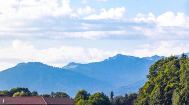 Avusturya 'nın Salzburg bölgesinde dağ ve dağ tepeleri dağları, kayalar ve tepeler yeşil çayır köyü orman kulübeleri ve mavi gökyüzü olan Alpler manzaralı panorama..