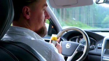 Doğu Alp Dağları 'nda Avusturya' nın güneyinde araba sürerken bir adam arabanın içinde zencefil içip sallanıyor..