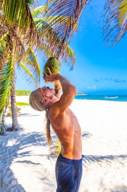 Playa del Carmen Quintana Roo Meksika sahilinde hindistan cevizi içen bir adam..