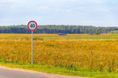 Belarus 'un Mir Karelichy İlçesi Hrodna Bölgesinde sonbaharda kırsal alanda trafik hız sınırı işareti.