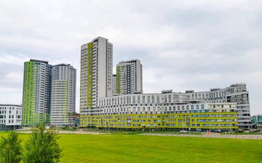 Minsk Bölgesi, Belarus 05. Eylül 2020 şehir yeşil turkuaz yeni yuvarlak yerleşim alanı binaları gökdelen parkı ve Minsk Belarus 'ta bulutlu gökyüzü inşa ediyor..
