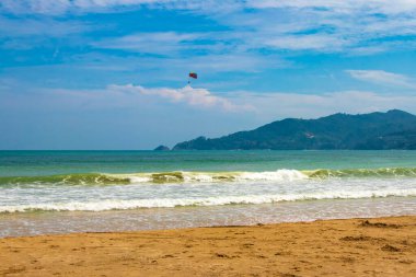 Patong Sahili sahil sahili manzarası turkuaz mavisi berrak su dalgaları ve yeşil dağlar ve Patong Sahili 'nde palmiye ağaçları ile Güneydoğu Asya' da Kathu Bölgesi Phuket Adası Bölgesi Güney Tayland.