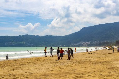 Kathu Phuket Tayland 11. Haziran 2018 Patong Sahili sahil manzaralı gezinti güvertesi turistleri açık mavi su dalgaları ve yeşil dağlar ve Patong Phuket Adası Tayland palmiye ağaçları.