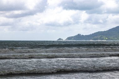 Patong Sahili Sahil Sahili manzaralı koyu fırtına muson yağmurları vahşi su dalgaları dağları ve Patong Sahili 'ndeki palmiye ağaçları Kathu Bölgesi Phuket Adası Güney Tayland Bölgesi.