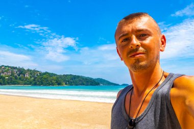 Güneydoğu Asya 'da Patong Sahili' nde turkuaz mavi su ve beyaz kumla gezen yakışıklı turist Kathu Bölgesi Phuket Adası Bölgesi Güney Tayland.