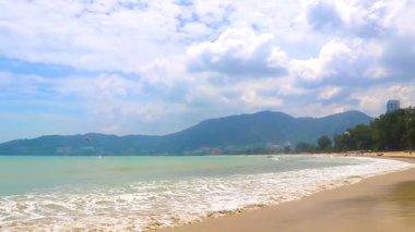 Kathu Phuket Tayland 11. Haziran 2018 Patong Sahili sahili deniz manzarası turkuvaz mavisi berrak su dalgaları ve yeşil dağlar ve Patong Phuket Adası Tayland palmiye ağaçları ile.
