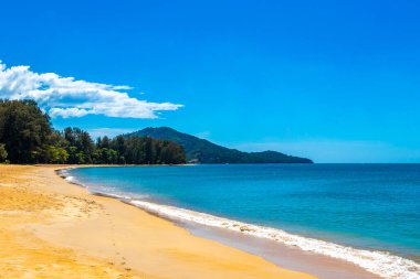 Tropical Mai Khao Beach and Naiyang Beach with jungle forest nature turquoise blue water waves and blue sky in Sirinat National Park Sakhu Thalang on Phuket island Province Southern Thailand.