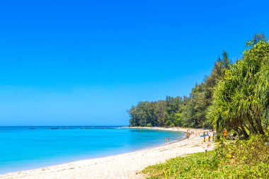 Tropical Mai Khao Beach and Naiyang Beach with boats mountains jungle forest nature turquoise water and blue sky in Sirinat National Park Sakhu Thalang District on Phuket island Thailand.