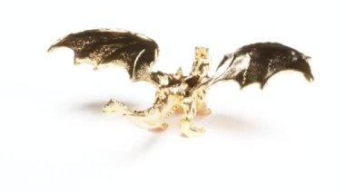 Beyaz yüzeyde parlayan altın ejder, 4k 'lık bir döngüye girebilir.