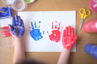 Beyaz kağıt üzerinde mavi ve kırmızı boya ile renkli el izleri yaratan çocuk, duyusal oyun konsepti, iyi motor beceriler geliştirme, çocukluk yaratıcılığı, sanat, hayal gücü, anaokulu eğitimi, erken ifade, eğlence zanaatı, evde öğrenme