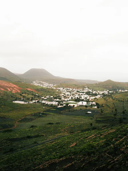 Beautiful view from hill on most green town of Lanzarote (Haria) between the hills and volcanic mountains. Green town with white house on rainy day.