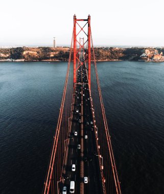 Portekiz 'in Lizbon kentinde bulunan 25 Nisan köprüsünün (Ponte 25 de Abril) Targus Nehri' ni geçerken çekilmiş dikey hava fotoğrafı..