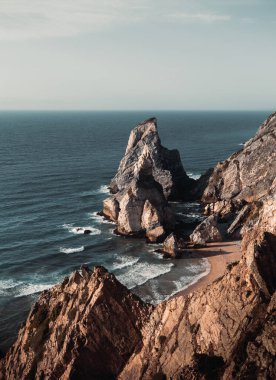 Portekiz 'deki Praia da Ursa plajının günbatımındaki görüntüsü. Avrupa 'nın en batısındaki Kayalık Ursa plajında dikey görüntü.