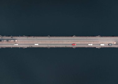 Arabalar, tramvaylar ve mavi suyla köprüden insansız hava aracı görüntüsü. Nehrin yukarısındaki köprüde insansız hava aracı tarafından çekilmiş yatay fotoğraf - uzun pozlu çekim.