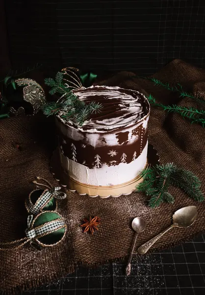 Dark food photo of glazed christmas chocolate cake with christmas decorations and balls - rustic and vintage style.