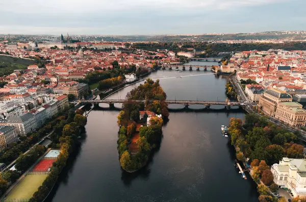 Prag şehrinin (Çek Cumhuriyeti) havadan görünüşü - sonbahar zamanı Vltava nehri ve eski kasaba üzerindeki ünlü köprüler (sonbahar mevsimi). Günbatımında yukarıdan Prag 'a, İHA' nın çektiği şehir manzarası konsepti..