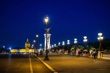Le Invalides Kilisesi ve Pont Alexandre Köprüsü Paris, Fransa 'da gece vakti aydınlandı.