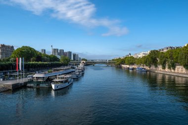 Gezinti güvertesi, demirli gemiler ve modern ofis binalarıyla Paris 'teki Seine Nehri.