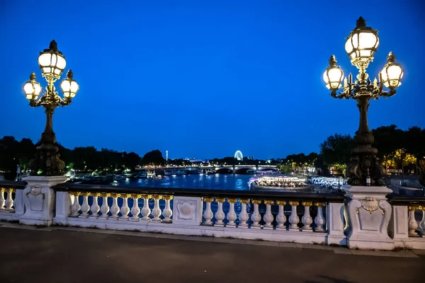 パリの夜のツアーボートでセーヌ川を渡ってイルミネーションされた橋 アレクサンドル3世 — ストック写真
