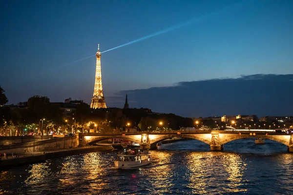 フランス 2022年8月15日 ライトアップされた橋ポン インヴァリッド オーバーリバーセーヌツアーボートとエッフェル塔への眺めパリの夜 フランス — ストック写真