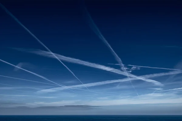 Błękitne Niebo Siatką Białych Szlaków Kondensacyjnych Kontrakty Samolotu Wybrzeżu Atlantyku — Zdjęcie stockowe