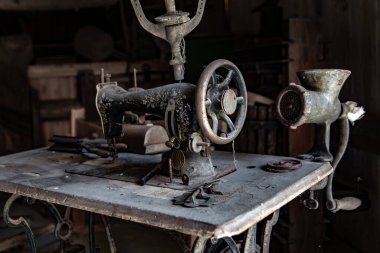 Eski Ahırdaki Masada Tozlu Vintage Elle Dikiş Makinesi ve Mutfak Aletleri