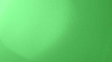Yeşil Arkaplanda Işık Sızıntısı. Arka plan için mercek aydınlatma kaplamaları. Kromakey. Ekranın sol üst köşesinde parlak bir ışık var. Video Renk Filtreleri. Geçiş.