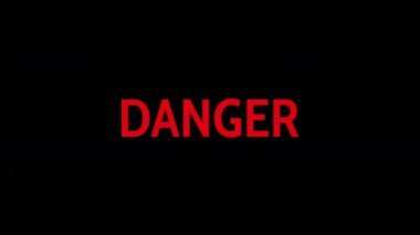 Siyah arka planda metin animasyonu - Tehlike. Parlak metin DANGER yakın tehlike hakkında kesin bir uyarı işlevi görüyor. Cesur, titreşimli mektuplar aciliyet ve ihtiyatı vurguluyor. 4K.