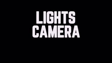 Siyah arkaplan üzerinde dinamik, sıralı kelime geçişleri olan LIGHTS CAMERA Action ifadesini içeren metin animasyonu. Bu minimalist ve cesur tasarım tanıtımlar ve sinematik fragmanlar için mükemmeldir.