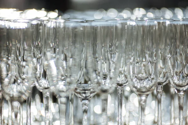 Restoranda bir grup boş ve şeffaf şampanya kadehi. Barmen tarafından şampanya için hazırlanmış temiz bardaklar. Etkinlik hazırlığı için servis, içki için boş bardaklar..