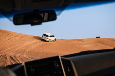 Dubai, Birleşik Arap Emirlikleri - 01 Temmuz 2021: Kum çölünde yarış. Yarış yarışı çölü. Araba toz bulutlarıyla yoldan çıkıyor. Yabanda engellerle yarışan off road aracı