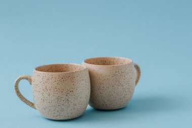 Mavi arkaplanda iki porselen boş bardak, boşluğu kopyala