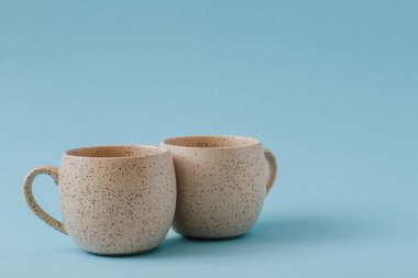 Mavi arkaplanda iki porselen boş bardak, boşluğu kopyala